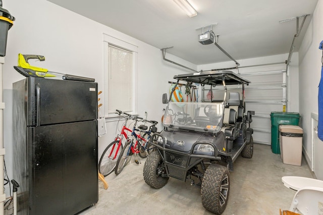 garage with a garage door opener and black fridge