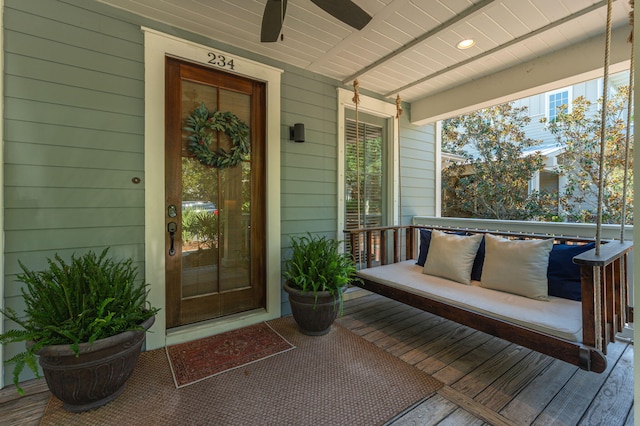 doorway to property featuring covered porch and ceiling fan