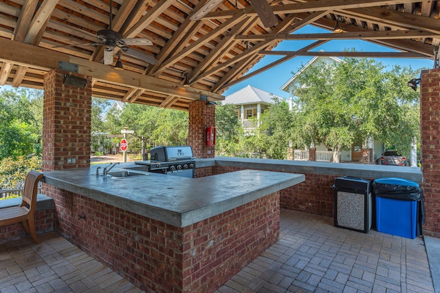 view of patio featuring area for grilling, exterior kitchen, a gazebo, an outdoor wet bar, and ceiling fan