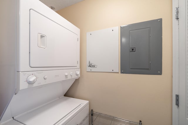 laundry room with electric panel and stacked washer and dryer