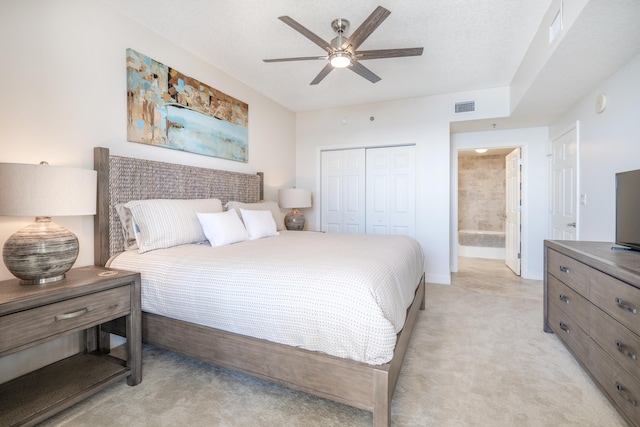 carpeted bedroom featuring ceiling fan, a closet, and ensuite bathroom