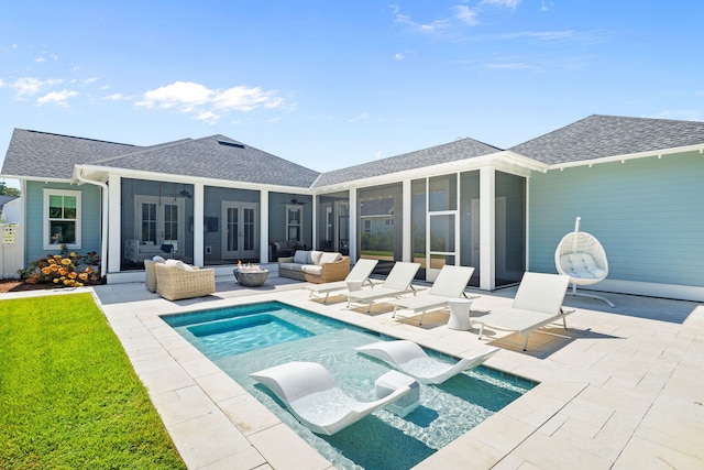 rear view of property with outdoor lounge area, a sunroom, and a patio area