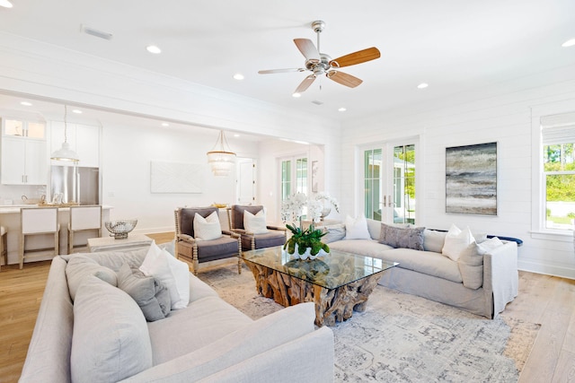 living room with ceiling fan, french doors, and light hardwood / wood-style flooring