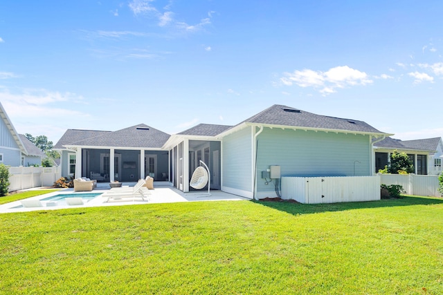 back of property with a sunroom, a yard, and a patio area