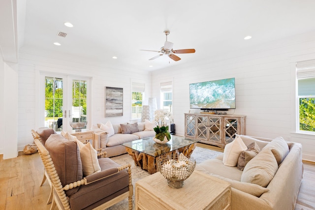 living room with ceiling fan, plenty of natural light, and light hardwood / wood-style floors