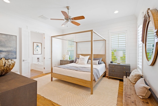 bedroom with ceiling fan, light hardwood / wood-style flooring, ensuite bathroom, and multiple windows