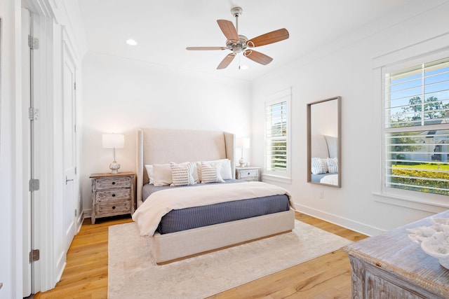 bedroom with crown molding, ceiling fan, and light hardwood / wood-style flooring