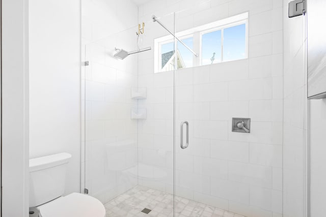 bathroom with a shower with door and toilet