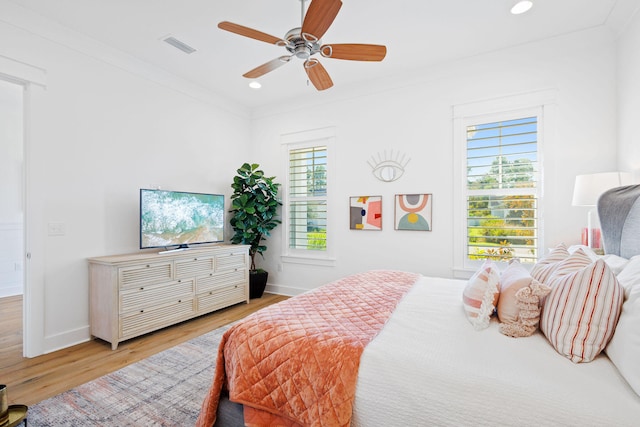 bedroom with ceiling fan, light hardwood / wood-style flooring, and ornamental molding