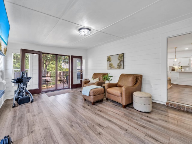 living area featuring light hardwood / wood-style floors and wooden walls