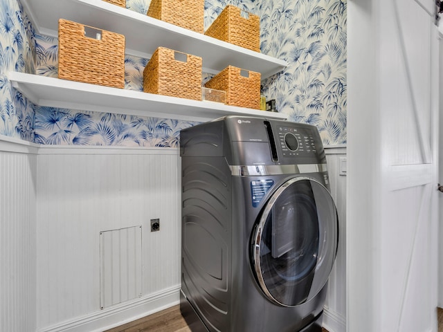 clothes washing area with dark wood-type flooring and hookup for an electric dryer