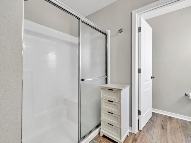 bathroom with hardwood / wood-style floors and walk in shower