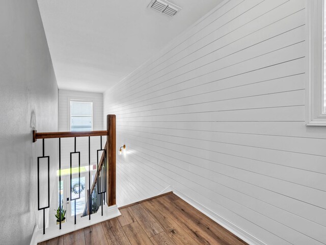 hall with wood walls and wood-type flooring