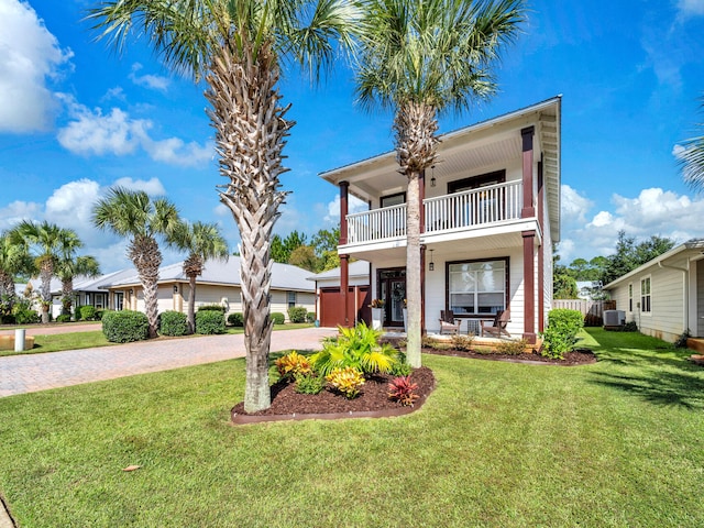 view of front facade featuring central air condition unit, a front yard, a garage, and a balcony