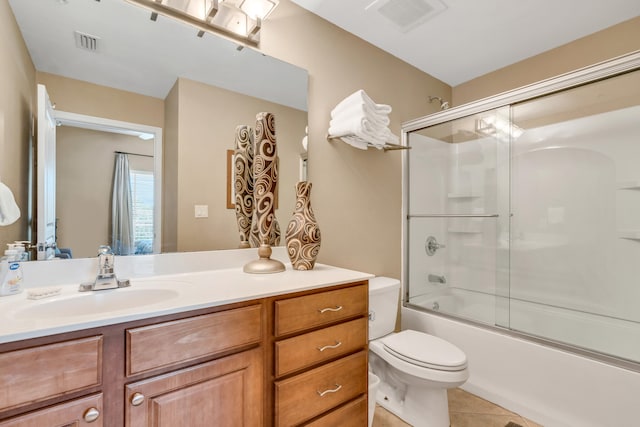 full bathroom featuring bath / shower combo with glass door, tile patterned floors, vanity, and toilet