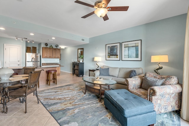 living room with light tile patterned flooring, ceiling fan, and rail lighting