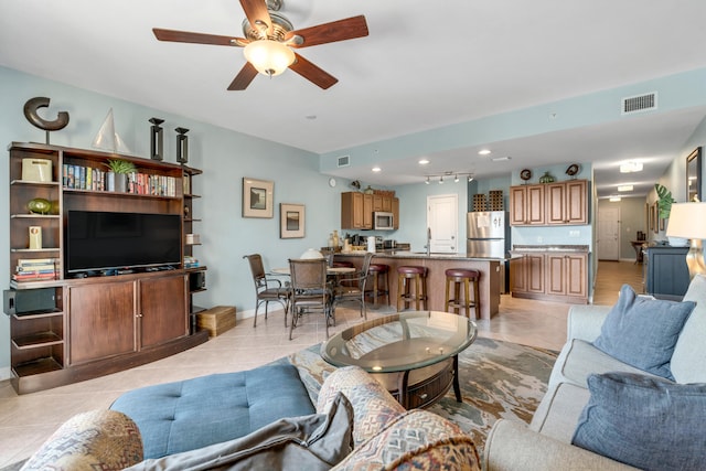 tiled living room with sink and ceiling fan