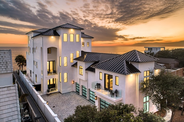 back house at dusk featuring a water view