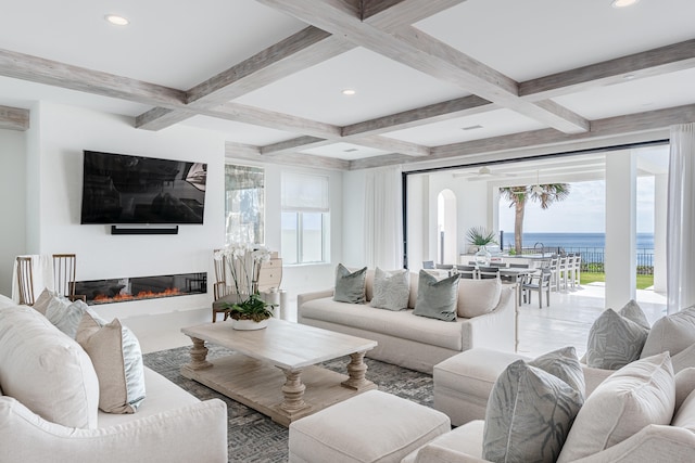 living room with a water view, beamed ceiling, and coffered ceiling