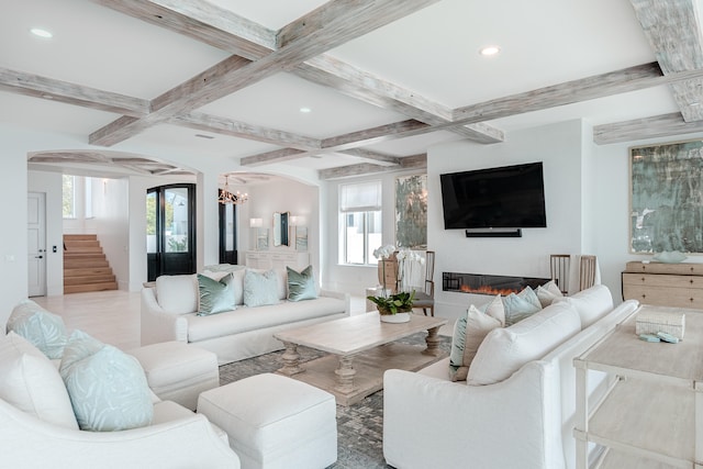 living room featuring coffered ceiling, beamed ceiling, and a healthy amount of sunlight