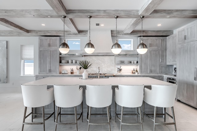 kitchen featuring a large island, decorative light fixtures, and plenty of natural light