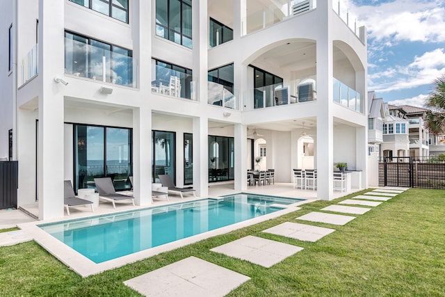 back of property featuring an outdoor hangout area, a balcony, a yard, and a patio