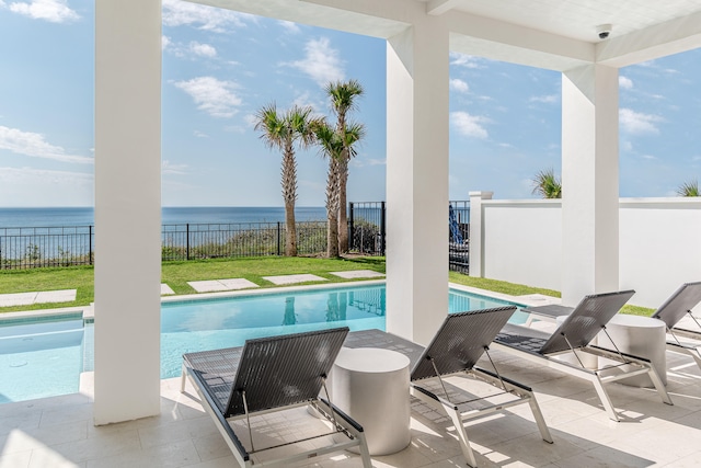 view of pool featuring a patio, a yard, and a water view