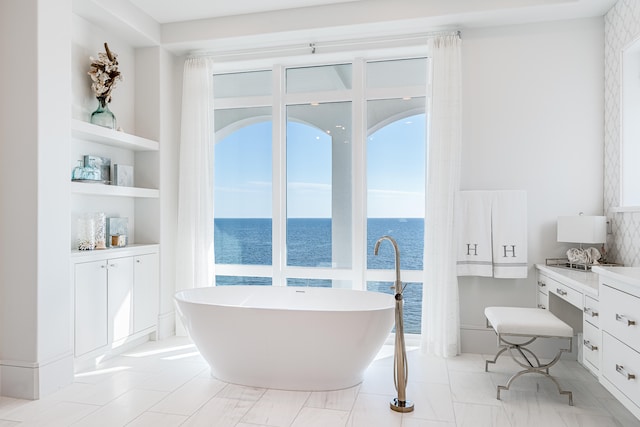 bathroom featuring vanity, a bathtub, and a water view