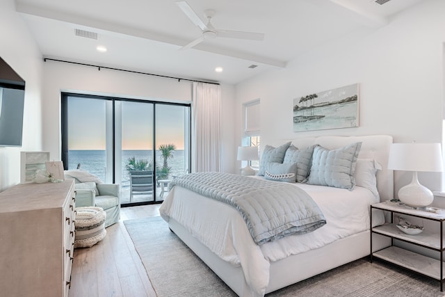 bedroom featuring a water view, beamed ceiling, ceiling fan, light hardwood / wood-style floors, and access to exterior