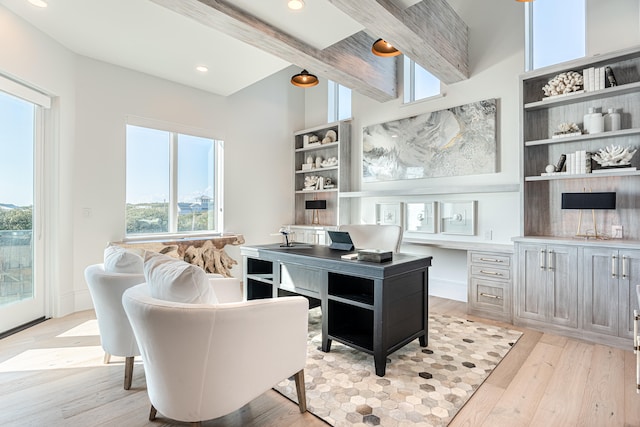 office with beam ceiling, built in desk, and light hardwood / wood-style floors