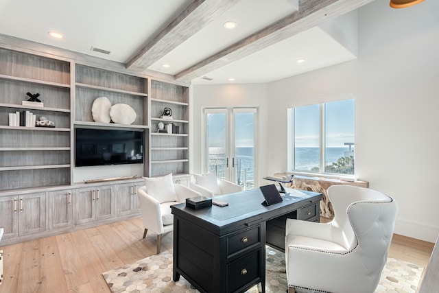 home office featuring light wood-type flooring and beam ceiling