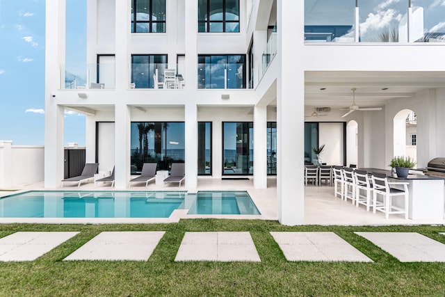 rear view of house with ceiling fan, a patio, and a balcony