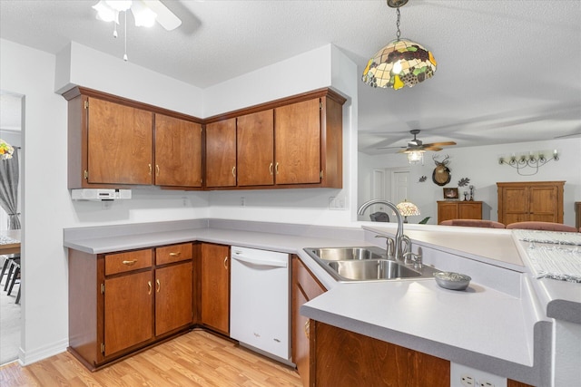 kitchen with a textured ceiling, pendant lighting, light hardwood / wood-style flooring, and dishwasher