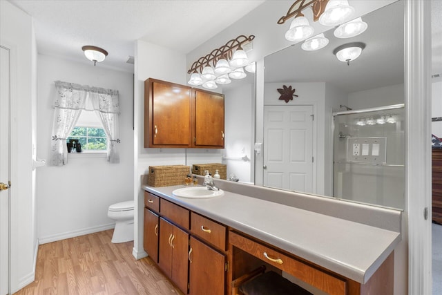 bathroom with vanity, an enclosed shower, wood-type flooring, a textured ceiling, and toilet