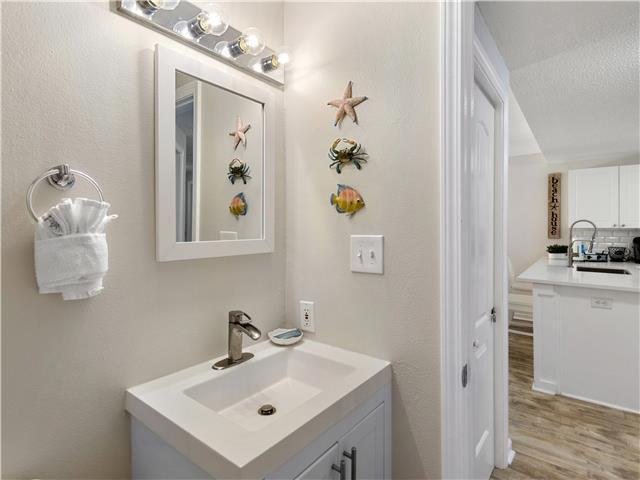2076 Scenic Gulf Dr Unit 1013, Miramar Beach, FL 32550 - bathroom with vanity, decorative backsplash, and wood finished floors