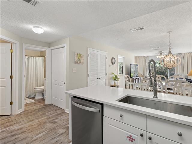 2076 Scenic Gulf Dr Unit 1013, Miramar Beach, FL 32550 - kitchen featuring stainless steel dishwasher, visible vents, light countertops, a textured ceiling, and a sink