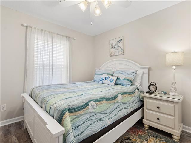 2076 Scenic Gulf Dr Unit 1013, Miramar Beach, FL 32550 - bedroom featuring a ceiling fan, baseboards, and dark wood-type flooring