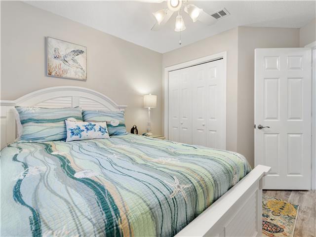 2076 Scenic Gulf Dr Unit 1013, Miramar Beach, FL 32550 - bedroom featuring a ceiling fan, a closet, wood finished floors, and visible vents