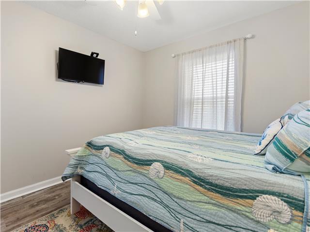 2076 Scenic Gulf Dr Unit 1013, Miramar Beach, FL 32550 - bedroom featuring baseboards, ceiling fan, and wood finished floors