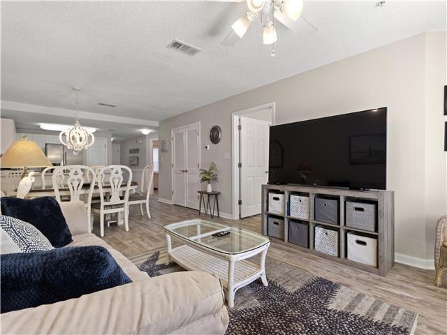 2076 Scenic Gulf Dr Unit 1013, Miramar Beach, FL 32550 - living room with baseboards, ceiling fan, visible vents, and wood finished floors