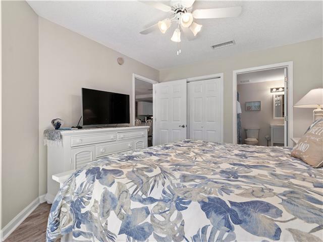 2076 Scenic Gulf Dr Unit 1013, Miramar Beach, FL 32550 - bedroom with visible vents, wood finished floors, baseboards, a closet, and connected bathroom