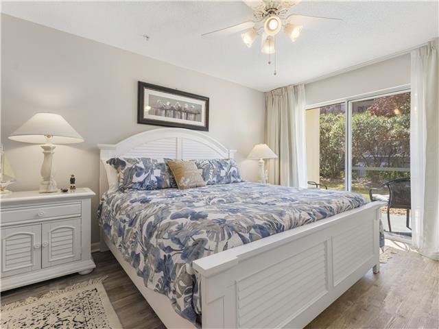 2076 Scenic Gulf Dr Unit 1013, Miramar Beach, FL 32550 - bedroom with ceiling fan, wood finished floors, and access to exterior