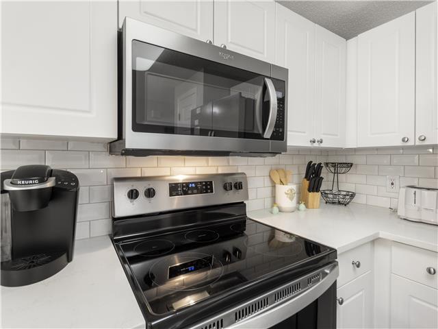 2076 Scenic Gulf Dr Unit 1013, Miramar Beach, FL 32550 - kitchen with light countertops, appliances with stainless steel finishes, and white cabinets