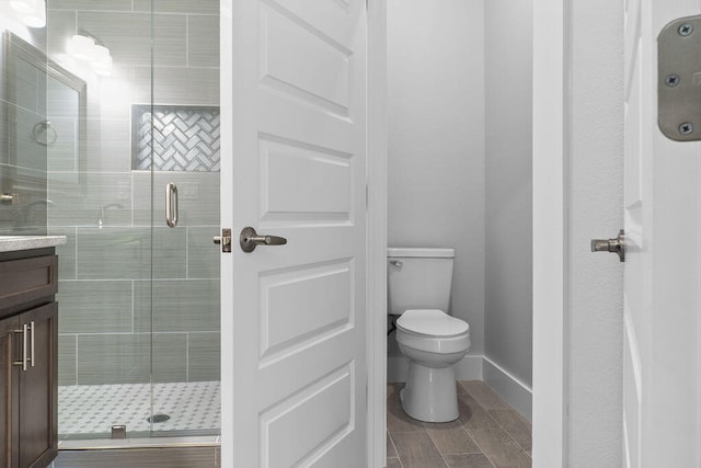 bathroom featuring walk in shower, vanity, and toilet