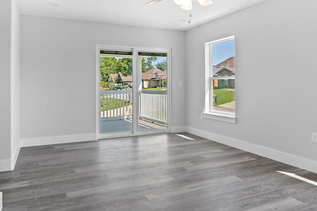 unfurnished room with ceiling fan, plenty of natural light, and dark hardwood / wood-style flooring