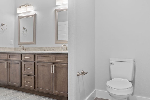 bathroom with vanity, toilet, and hardwood / wood-style flooring