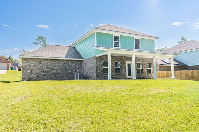 view of front of property with central AC and a front lawn