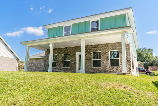 rear view of house with a porch and a yard