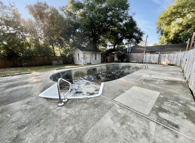 view of pool featuring an outbuilding and a patio area