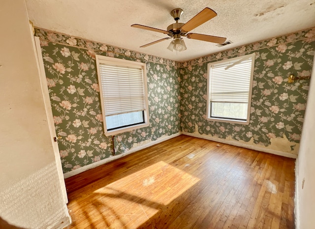 unfurnished room with ceiling fan, a textured ceiling, and hardwood / wood-style floors